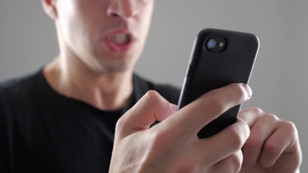 Hombre enojado usando Smartphone. Furioso hombre gritando con teléfono inteligente en la mano — Vídeos de Stock