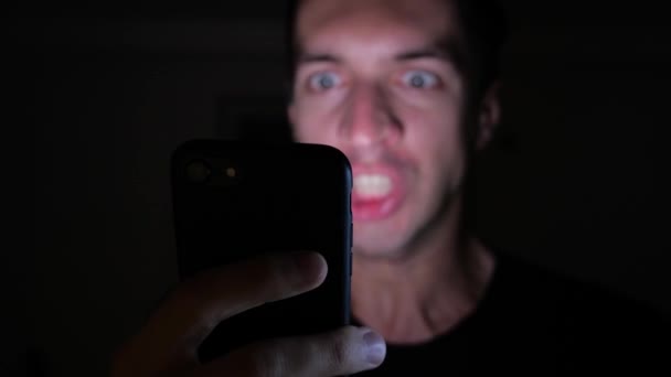 Angry Man Using Smartphone at Night. Furious yelling man with smartphone in hand — Stock Video