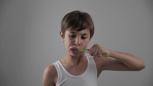 Ein kleiner Junge putzt sich im Badezimmer die Zähne und hört auf, wegen Zahnschmerzen zu leiden. Zahnprobleme — Stockvideo