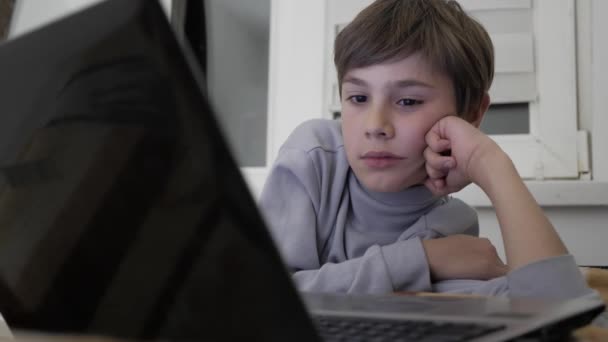 Niño niño viendo vídeo en el ordenador portátil en casa en la cama . — Vídeos de Stock