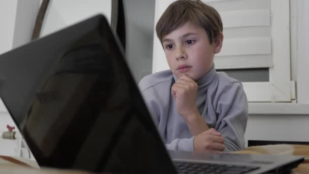 Bambino ragazzo guardando video su computer portatile a casa sul letto . — Video Stock