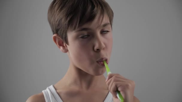 Ein kleiner Junge putzt sich im Badezimmer die Zähne und hört auf, wegen Zahnschmerzen zu leiden. Zahnprobleme — Stockvideo