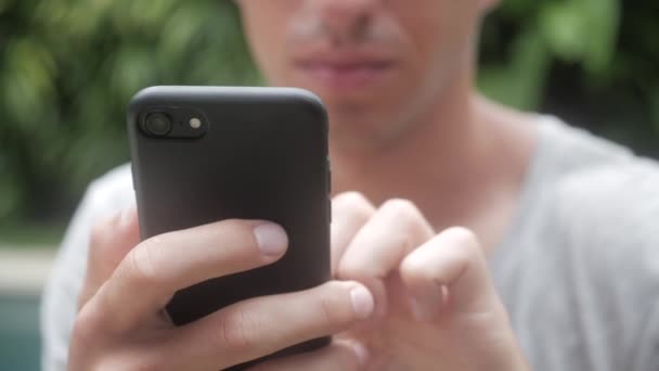 Close up van man met smartphone buiten. Jonge man met tablet pc. Een man op tuin op sociale netwerken met behulp van een smartphone. — Stockvideo