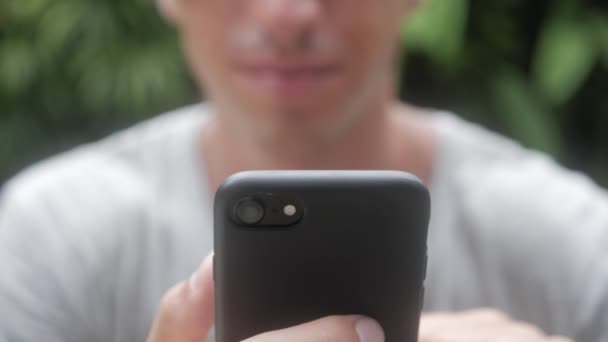 Gros plan de l'homme en utilisant smartphone extérieur. Jeune homme avec tablette. Un homme au jardin sur les réseaux sociaux utilisant un smartphone . — Video