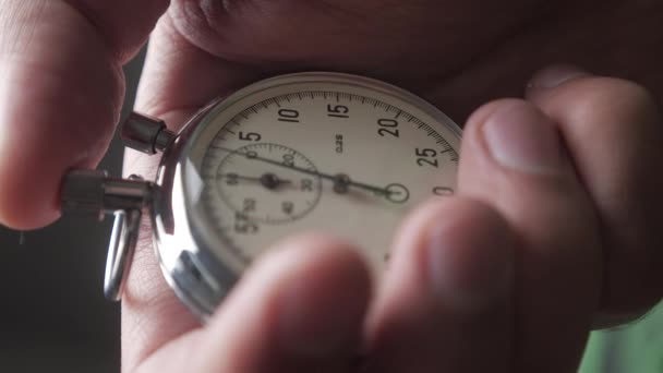 Close-up van één persoon een stopwatch op grijze achtergrond opstarten. 4k, 10 Bit, 4:2:2. — Stockvideo