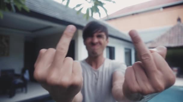 Портрет человека, стреляющего Fuck You на улице перед домом . — стоковое видео