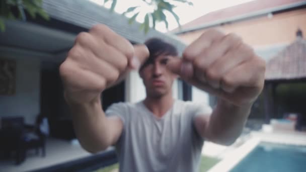 Porträtt av mannen visar Fuck You utomhus framför huset. — Stockvideo