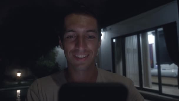 젊은 남자는 마당에 밤에는 스마트폰을 사용 하 — 비디오