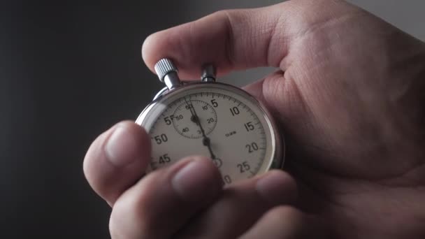 Primer plano de una persona que pone en marcha un cronómetro con fondo gris. 4K, 10 BIT, 4: 2: 2 . — Vídeo de stock