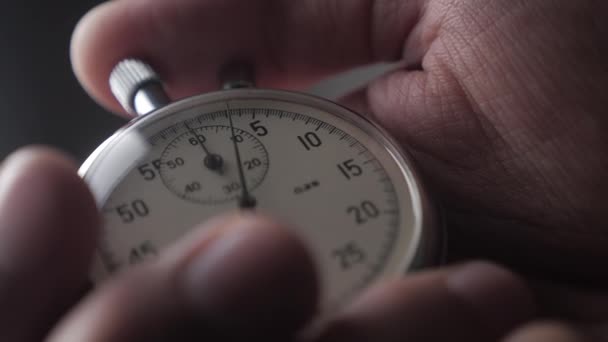 Close-up van één persoon een stopwatch op grijze achtergrond opstarten. 4k, 10 Bit, 4:2:2. — Stockvideo