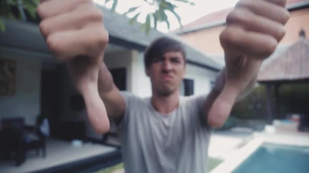 Thumbs Down with Both Hands by Young Man, em casa no pátio, ao ar livre. Conceito de discordância — Vídeo de Stock