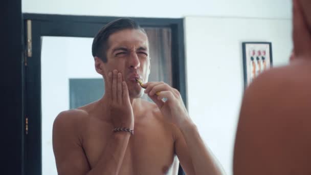 Portrét člověka, čistit si zuby v koupelně a zastavení becuse bolesti zubu. Zubní problémy — Stock video