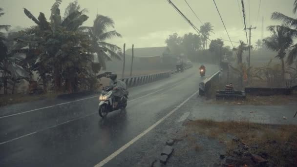 Ubud, Bali, Indonézia - 2018. December 02.: Ázsia, emberek lovagolni motorkerékpár az úton, esőben az esős évszak alatt — Stock videók