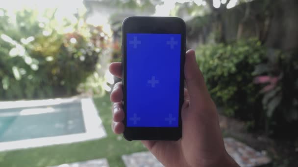 Primer plano de manos masculinas tocando de teléfono inteligente al aire libre en el jardín. Tecla de croma de pantalla azul . — Vídeos de Stock