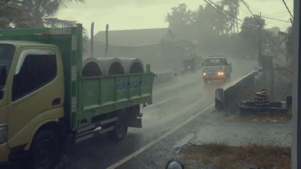 UBUD, BALI, INDONESIA - 02 DE DICIEMBRE DE 2018: Tráfico a lo largo de la calle típica en la carretera durante la lluvia en Ubud, isla Bali, Indonesia — Vídeo de stock