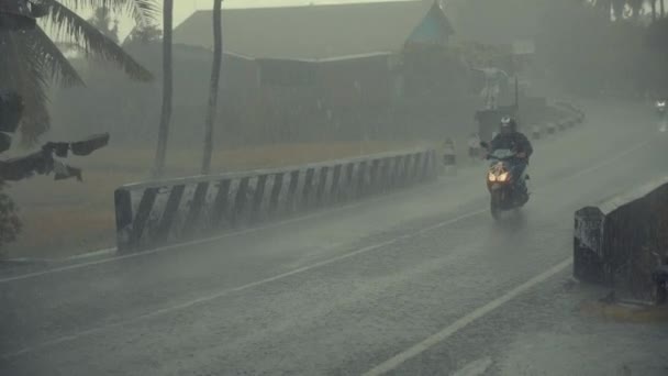 Ubud, Bali, Indonésie - 02 prosinec 2018: Provoz v období dešťů v Asii. Místní lidé jezdit motocykly po silnici v dešti během období dešťů — Stock video