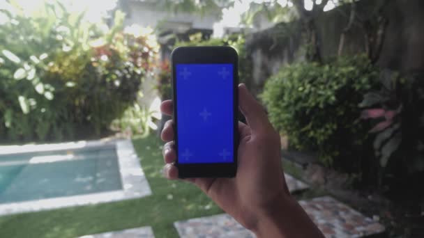 Primer plano de manos masculinas tocando de teléfono inteligente al aire libre en el patio. Tecla de croma de pantalla azul . — Vídeo de stock