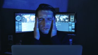 Gözlüklü yorgun bilişim programcısının portresi bilgisayarda çok çalışıyor. Başı ağrıyor.