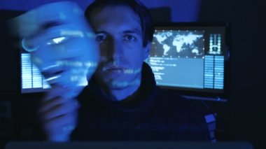 Cherkassy, Ukrayna, 04 Ocak 2019: Hacker gizler yüzünü karanlık odada Guy Fawkes maskesi arkasında dolu ekranları görüntülemek.