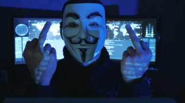 Cherkassy, Ukrayna, 04 Ocak 2019: Hacker anonim maskeli adam Fawkes gösterilen Fuck You göstermek perde ile dolu karanlık bir odada.