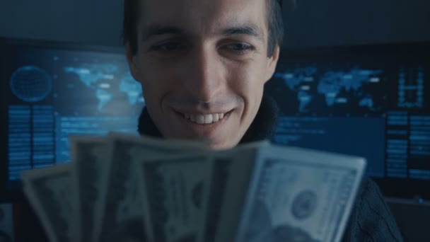 Portrait of Hacker Programmer counts Money earned ith criminally on Darknet in cyber security center filled with display screens. — Stock Video