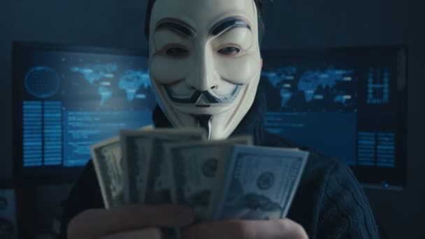 Cherkassy, Ucrania, 04 de enero de 2019: anónimo en Guy Fawkes máscara cuenta las facturas de dólares ganados por la piratería en la red oscura — Vídeos de Stock