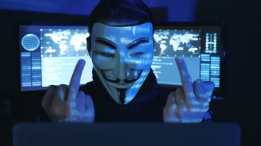 Cherkassy, Ukrayna, 04 Ocak 2019: Hacker anonim maskeli adam Fawkes gösterilen Fuck You göstermek perde ile dolu karanlık odada.