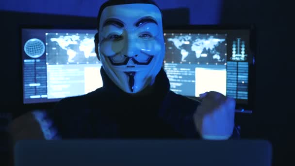 Cherkassy, Ukraina, januari 04 2019: Förvånad förvånad ung Hacker anonym i mask av Guy Fawkes i mörkt rum fyllda med skärmar. Plötslig seger eller framgång — Stockvideo