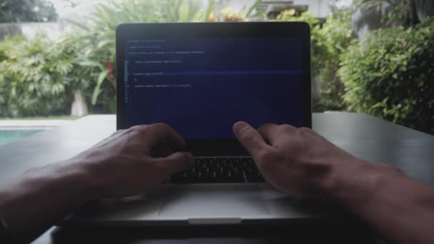 Eerste-persoon portret programmeur ontwikkelaar programmeur freelancer schrijft code op een laptop buiten het kantoor — Stockvideo