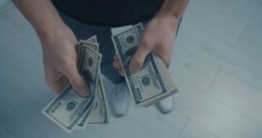 Genç adam ofiste ayakta doları notlar anlatıyor. El, el, para dolar para sayar