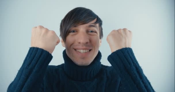 Retrato de Happy Young Man en jersey negro sobre fondo blanco. Emociones de alegría y deleite — Vídeos de Stock