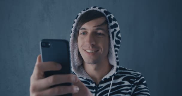 Портрет молодого чоловіка в кігурумі зебрах за допомогою смартфона — стокове відео