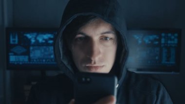 Mahalledeki tehlikeli Hacker ekranlarla dolu bir gizli veri merkezindeki bir akıllı telefon kullanır