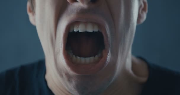 Gros plan sur la bouche d'un homme en colère qui crie. Menace de violence. — Video