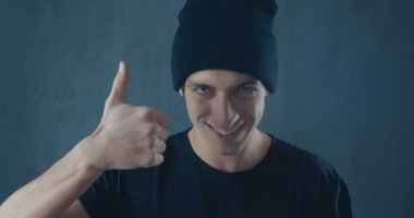 Portrait of Amazed Surprised Young Man in Black Shirt. Sudden Victory or Success. Victory concept. Thumb up