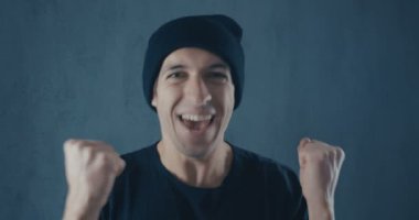 Portrait of Amazed Surprised Young Man in Black Shirt. Sudden Victory or Success. Victory concept. Thumb up