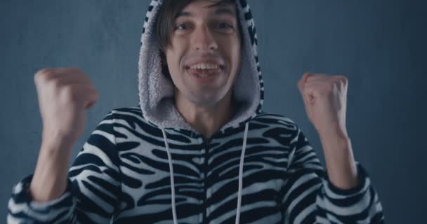 Portrait of Happy Young Man in kigurumi zebras on gray background. Emotions of joy and delight — Stok video