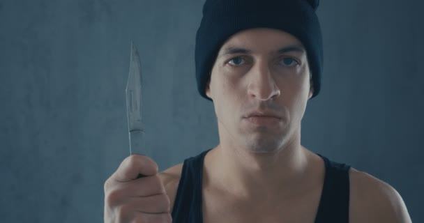 Портрет опасного человека в кепке с ножом — стоковое видео