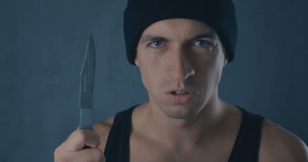 Porträtt av farliga mannen i ett lock med en kniv — Stockvideo