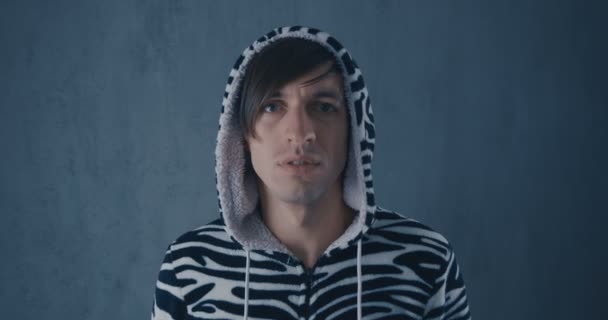 Portrét mladé muže v kigurumi zebry na šedém pozadí. — Stock video
