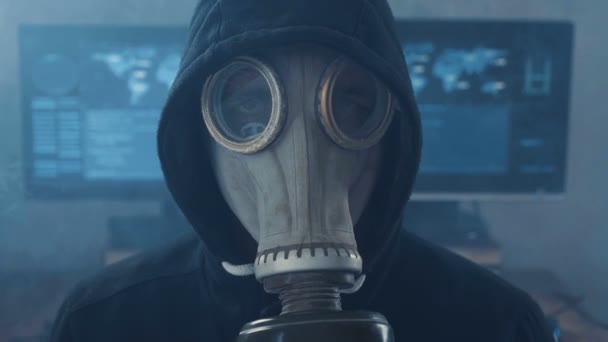 Portret van Hacker in gasmasker en capuchon in rook cyber Beveiligingscentrum gevuld met beeldschermen. Wereld van postapokalipsis — Stockvideo