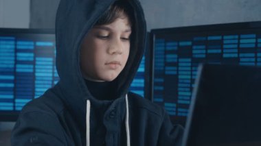 Genç dahi çocuğu hacker programcı ile dolu veri merkezi bilgisayara çalışma başlıklı ekranları görüntülemek. Harika çocuk hacker portresi.