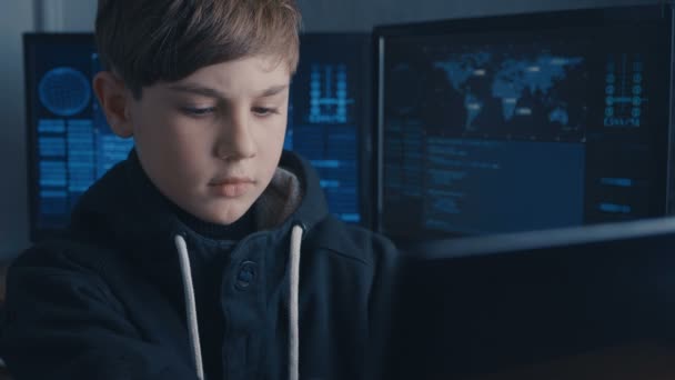 Boy Wunderkind Hacker Hacks Computer Systems. em Data Center com mapas e dados em telas de exibição — Vídeo de Stock