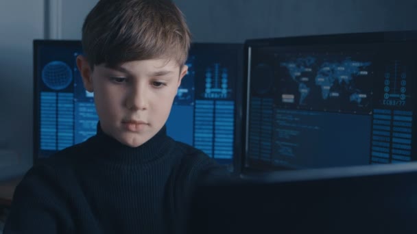 Pojke Wunderkind Hacker hacka datorsystem. i datacentret med kartor och data på skärmar — Stockvideo
