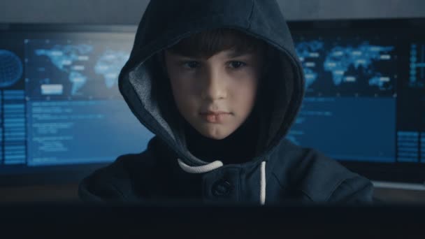 Zobrazovacími jednotkami mladí prodigy boy hacker programátor v práci s počítačem v datovém centru s kapucí. Portrét zázračné dítě hackera. — Stock video