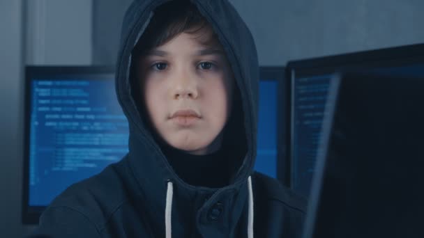 Retrato de un joven prodigio Boy Hacker Programador en el centro de datos lleno de pantallas de visualización. Retrato de niño hacker prodigio . — Vídeo de stock