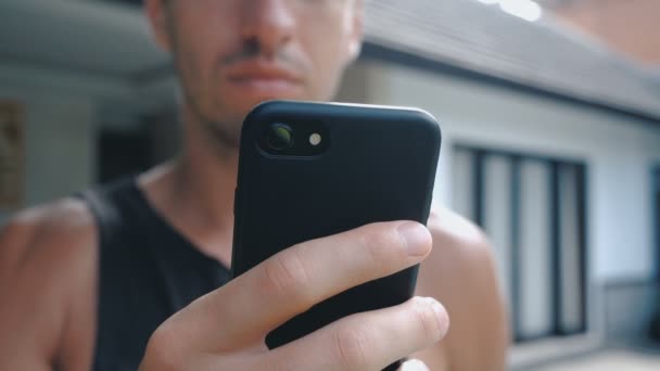 Close up of man using smartphone outdoor. Young man with tablet computer. A man at yard near house on social networks using a smartphone. — Stock Video