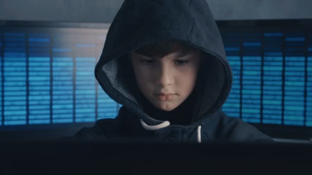 Portrait of a Genius Boy Hacker Prodigy in the hood working on computer in secret data center — Stock Video