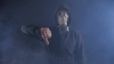 Gaz maskesi ve Hood Stalker dumanlı karanlık yer gösteren, aşağı ve söyleyerek hiçbir Thumbs.