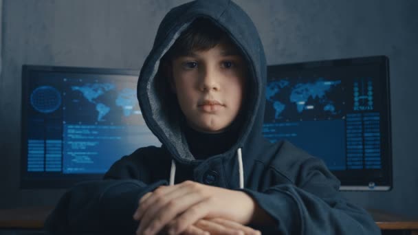 Boy wonder Hacker in kap in datacenter gevuld met schermen. Portret van wonderkind hacker. — Stockvideo